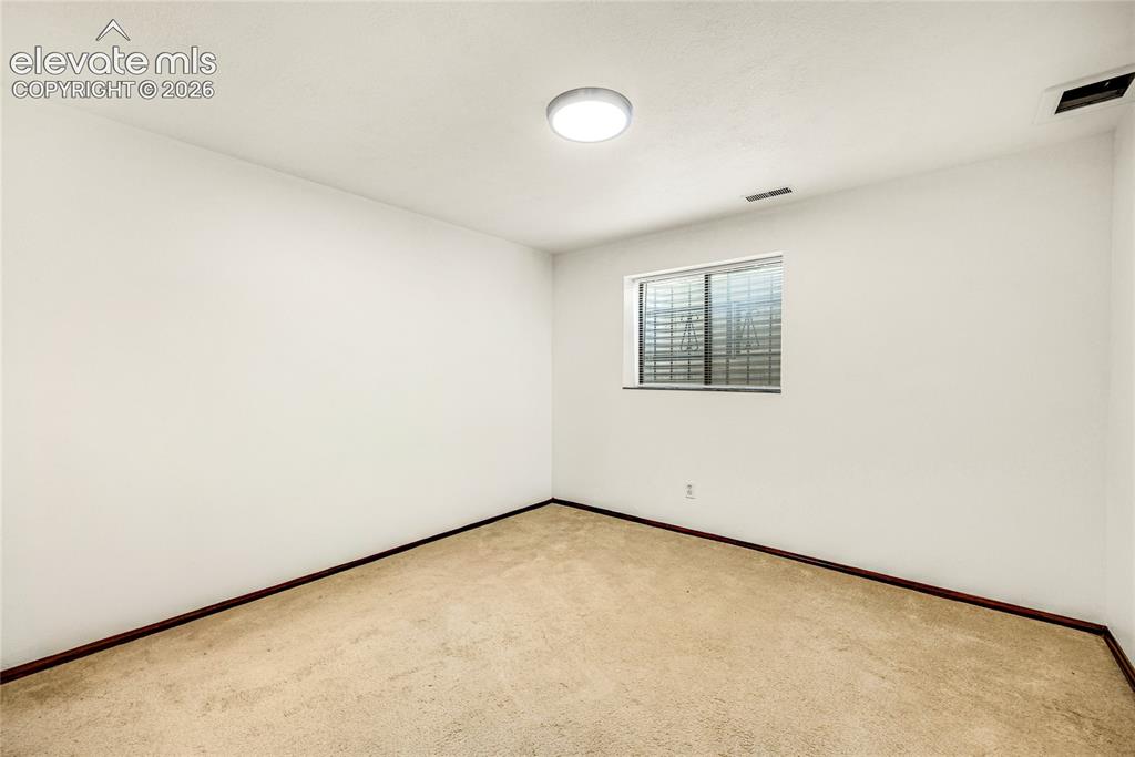 Image 29 of 46: Carpeted interior room featuring a single window and flush-mount ceiling li