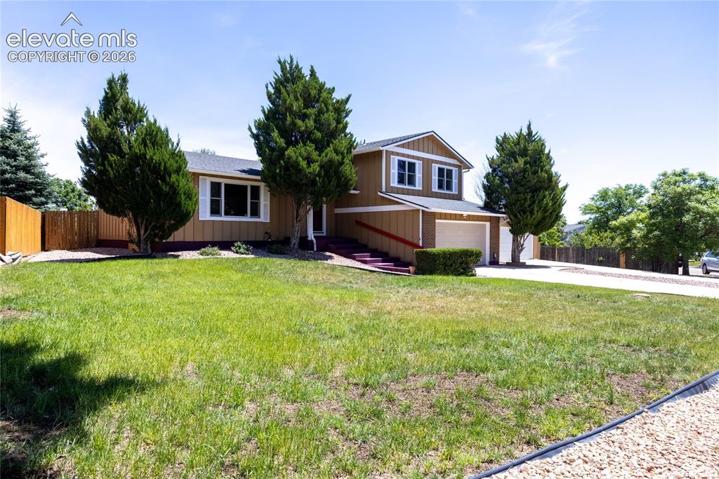 Image 3 of 46: Split-level residence featuring a multi-car driveway and an attached two-ca