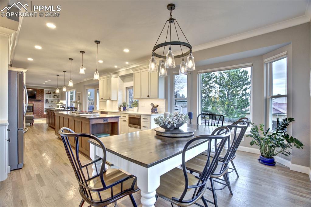 Image 13 of 50: Dining room with bay window, hardwood floors, chandelier, open to the spaci