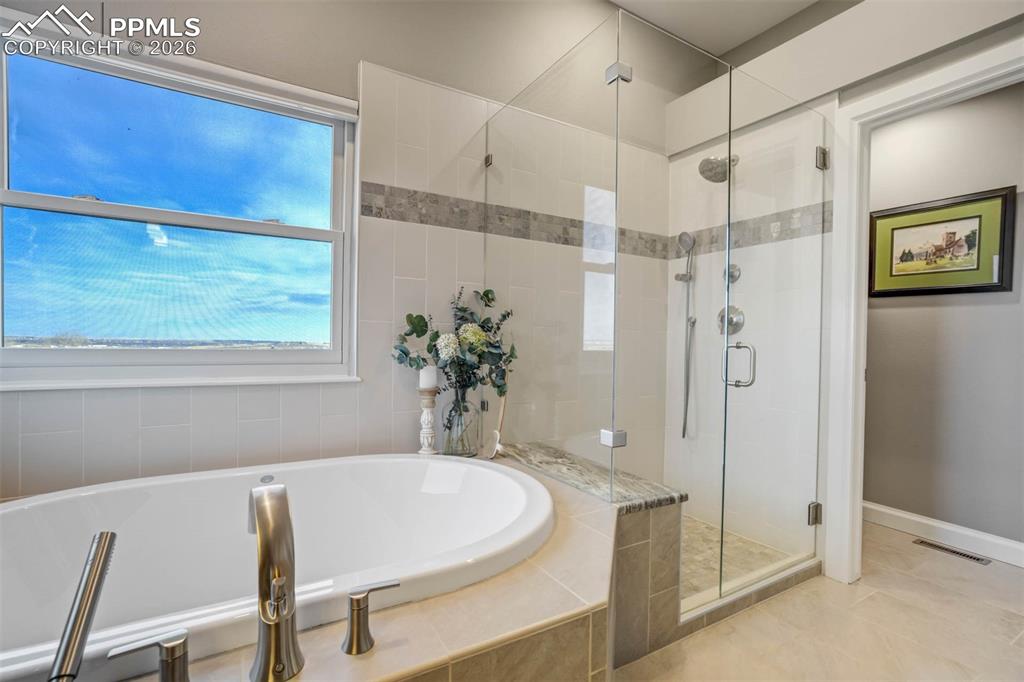Image 25 of 50: Primary bathroom with large soaking tub, pretty fixtures, large separate sh