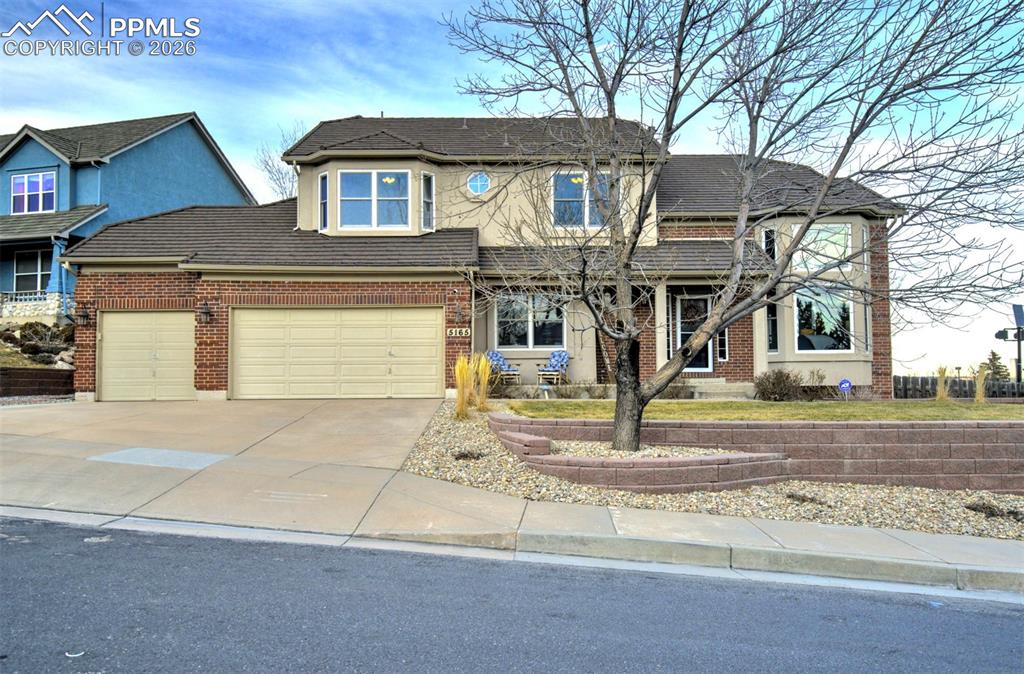 Image 3 of 50: Street view of the front of this home, showing stucco and brick exterior, c