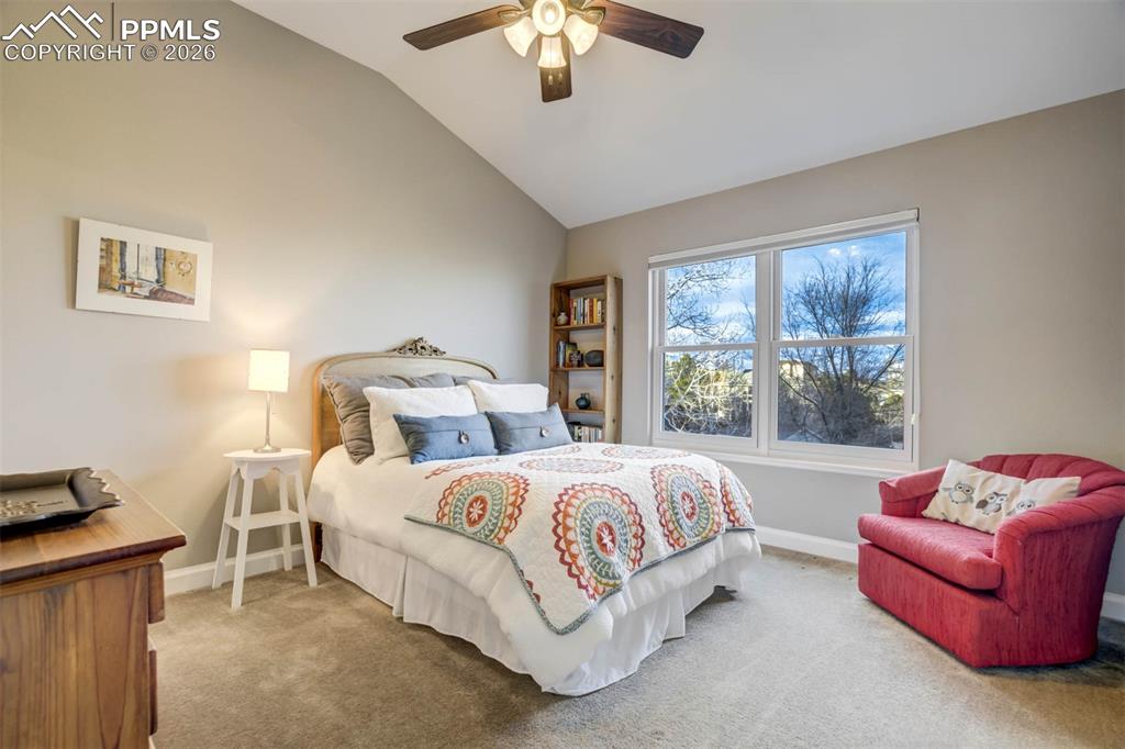 Image 32 of 50: Bedroom 4 with lofted ceiling, a ceiling fan w/lights and carpet