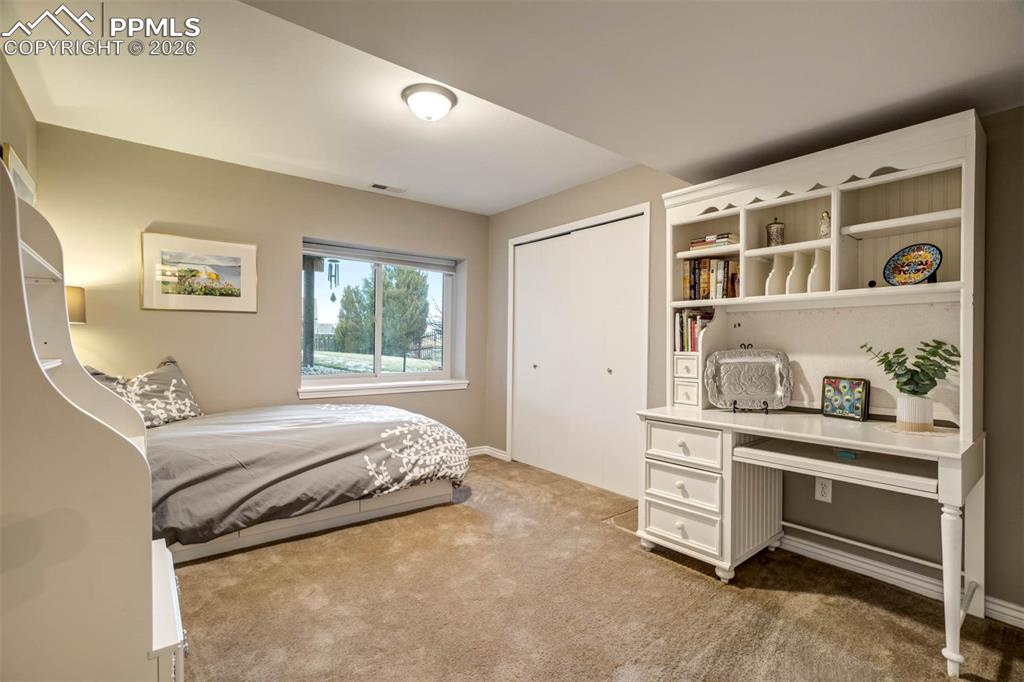 Image 40 of 50: Bedroom 5(basement) with large window and light carpet.