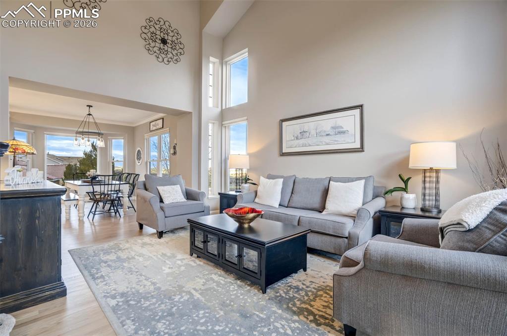 Image 7 of 50: Spacious Living Room area with plenty of natural light, a high ceiling, har