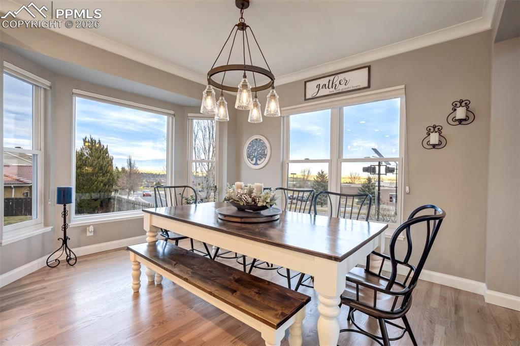 Image 8 of 50: Light filled Dining area featuring hardwood flooring, ornamental molding, l
