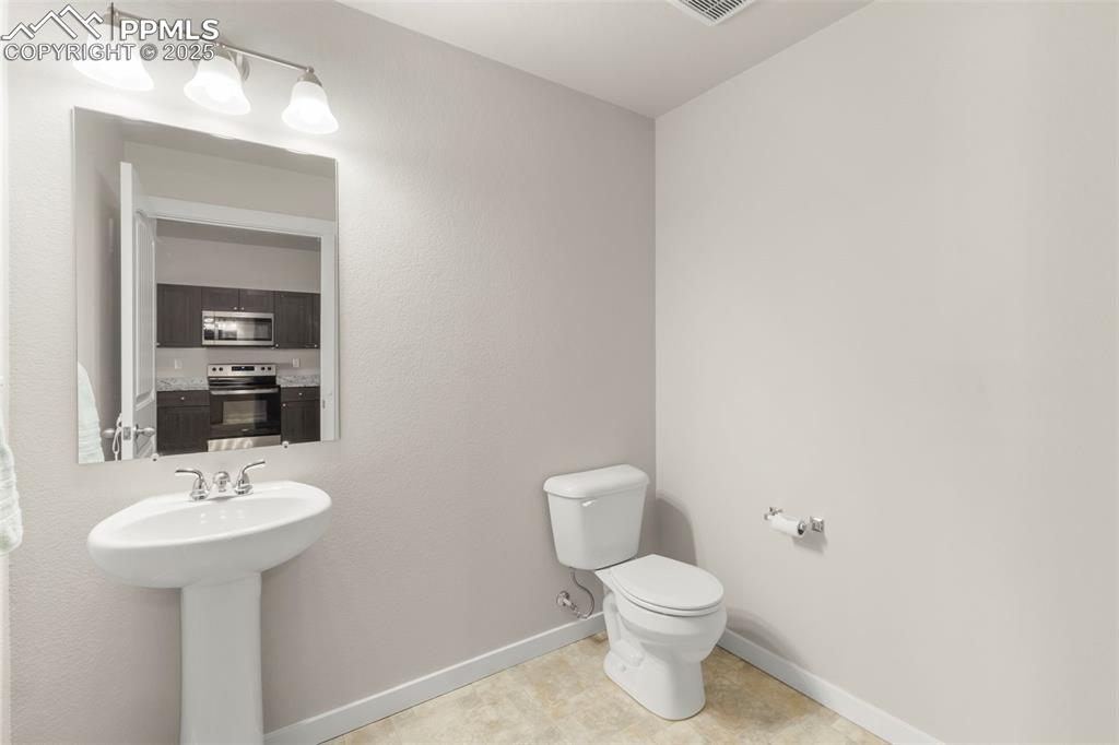Image 14 of 27: Bathroom featuring toilet and light tile patterned floors