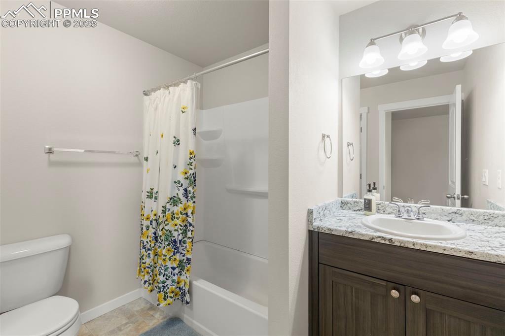 Image 18 of 27: Bathroom with vanity and shower / bath combo with shower curtain