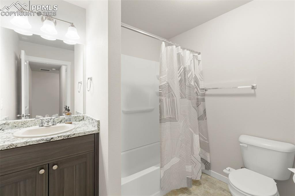 Image 25 of 27: Bathroom featuring shower / tub combo with curtain and vanity