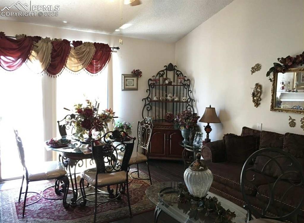 Image 2 of 20: Dining space featuring wood finished floors, a textured ceiling, and a ceil