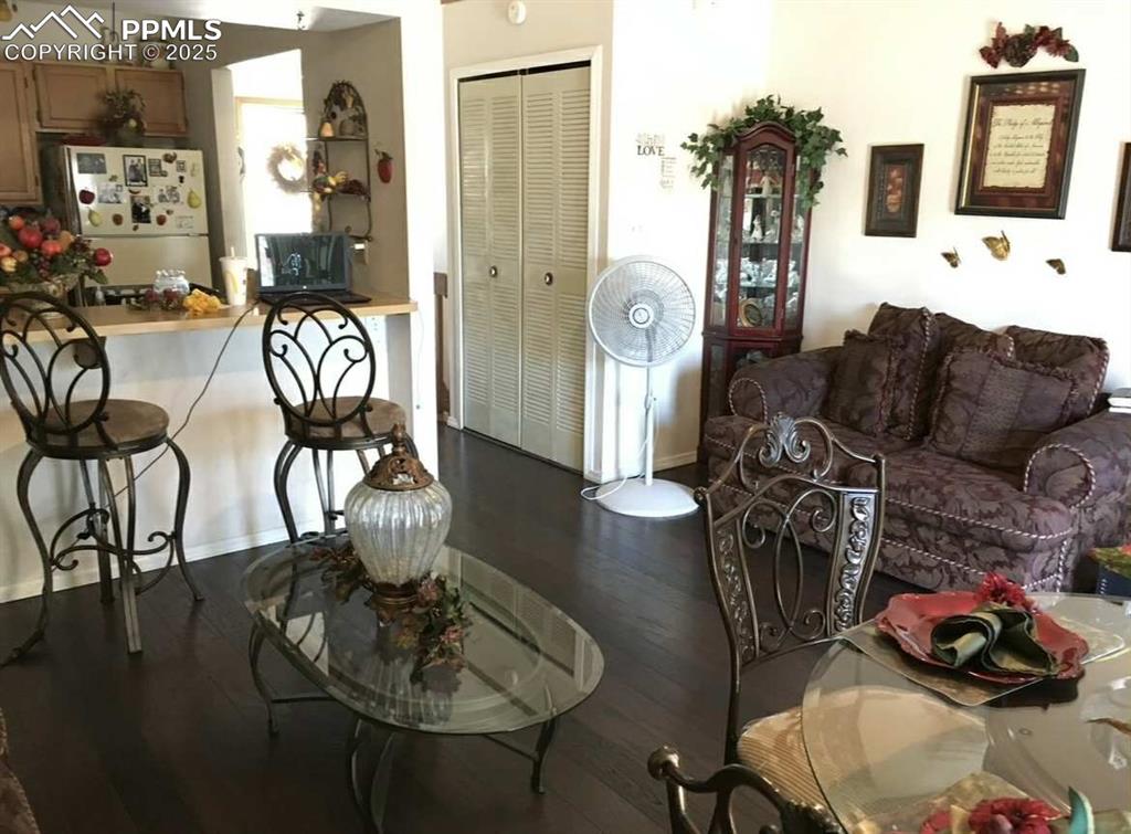 Image 4 of 20: Living room with dark wood finished floors and baseboards