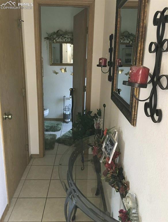 Image 9 of 20: Hall featuring light tile patterned floors and baseboards