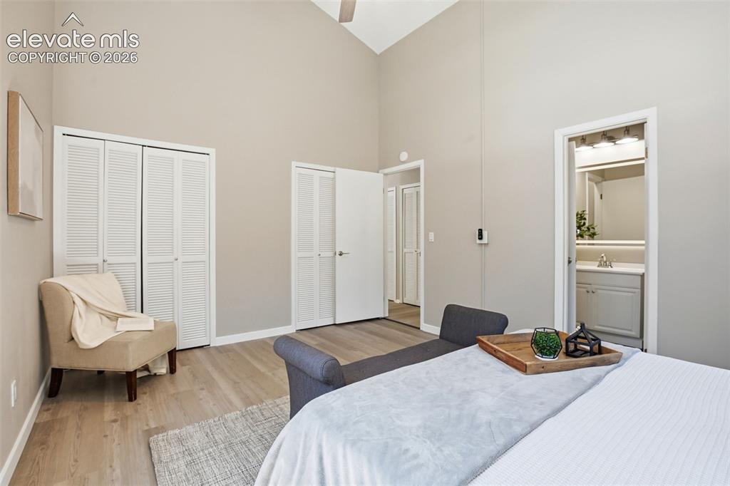 Image 11 of 19: Spacious room featuring vaulted ceilings, wood-finish flooring, two sets of