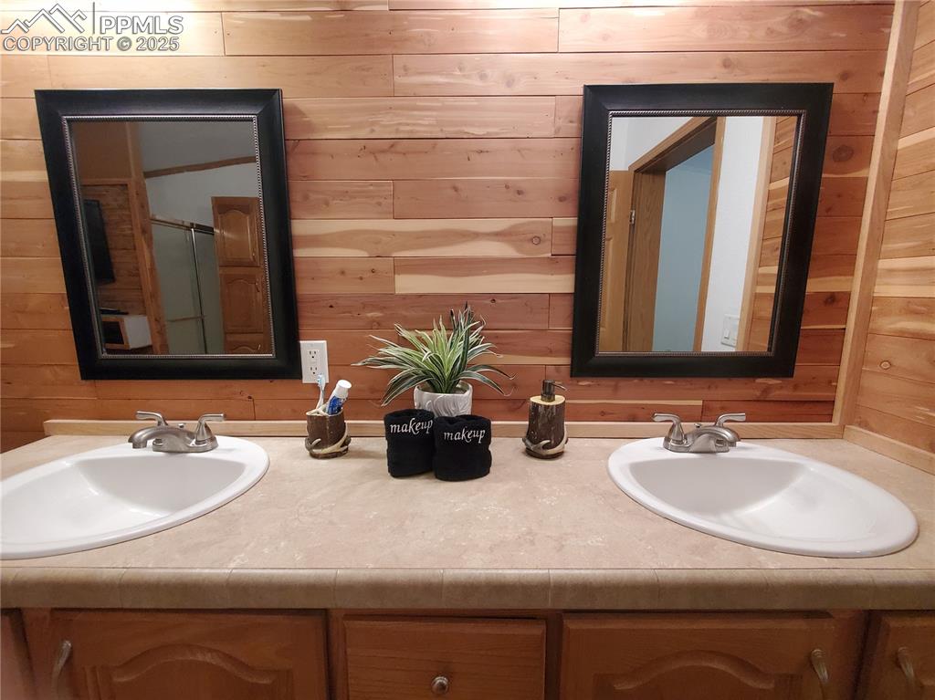 Image 17 of 50: Double sink vanity is spacious with rustic wood on the wall which adds cozi