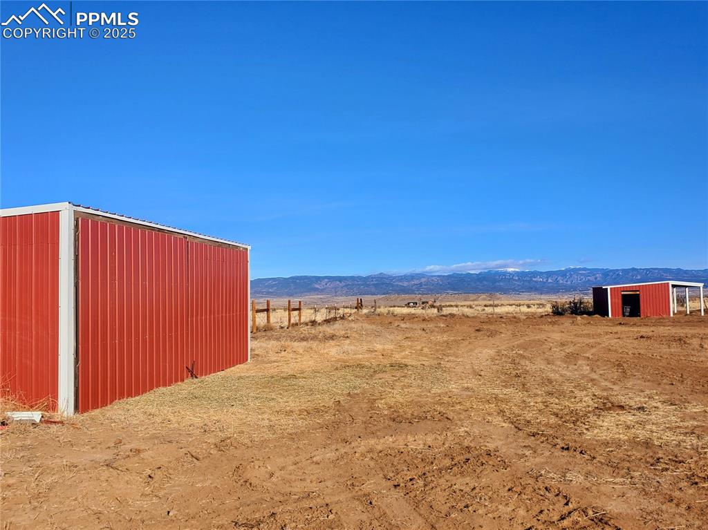 Image 43 of 50: Hay/feed storage building on left, horse stable on the right for a total of