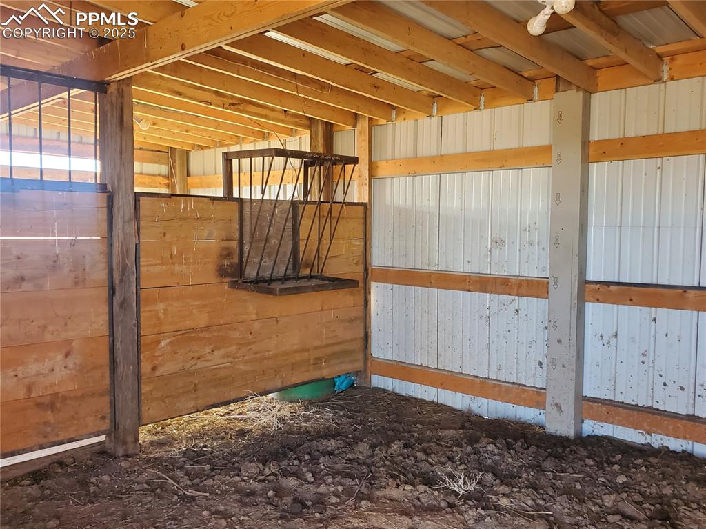 Image 45 of 50: Stable has feeder, storage and is lighted