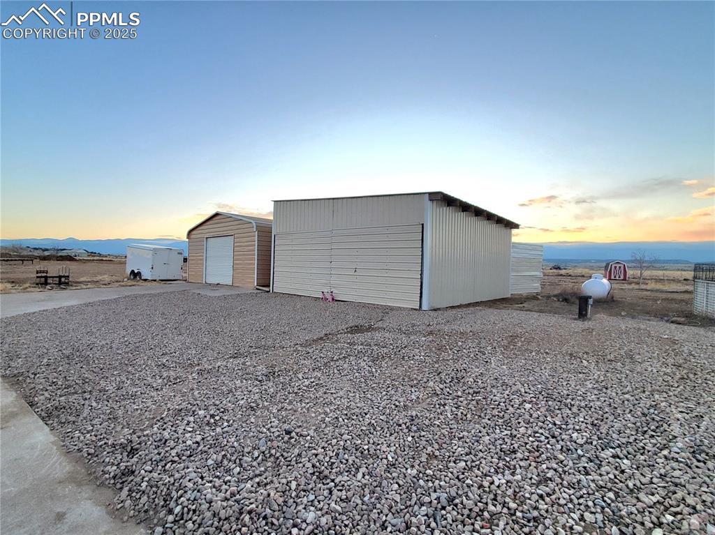 Image 46 of 50: Left is a 2 car pull behind garage/workshop The right hand building is a pu