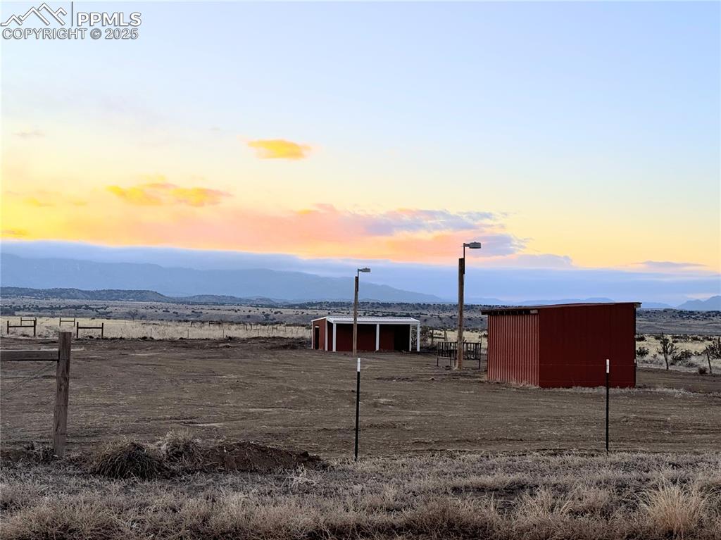 Image 5 of 50: stable has lights inside. Property has mountain views from the SW all the w