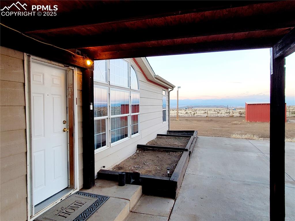 Image 8 of 50: Main entry door with raised beds perfect for growing herbs, veggies, and fl