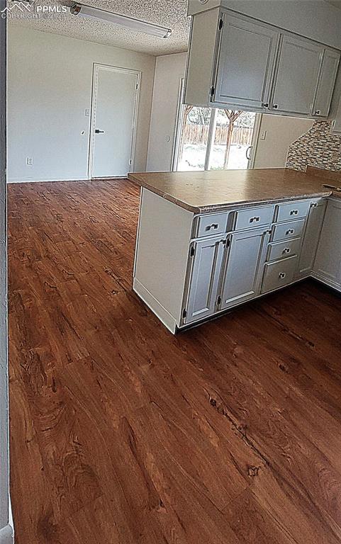 Image 24 of 46: Kitchen to dining area with walkout to back yard yard with dark wood-style