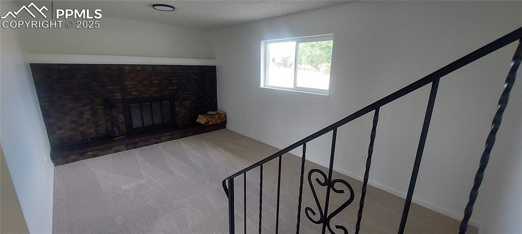 Image 34 of 46: featuring carpet, a fireplace, and a textured ceiling