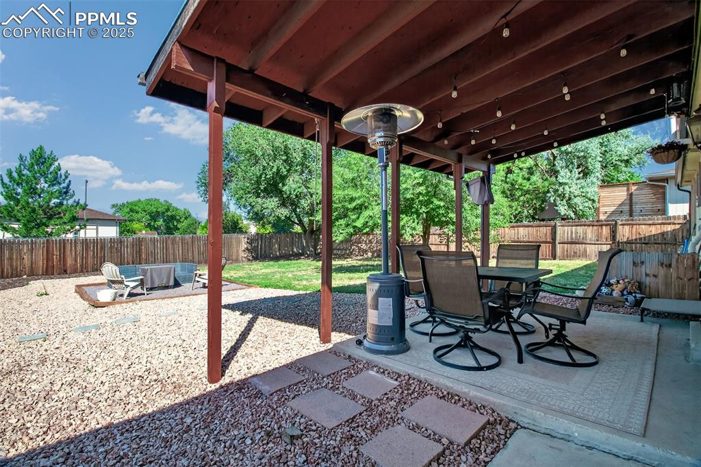 Image 17 of 29: Wonderful covered patio with firepit area and yard.