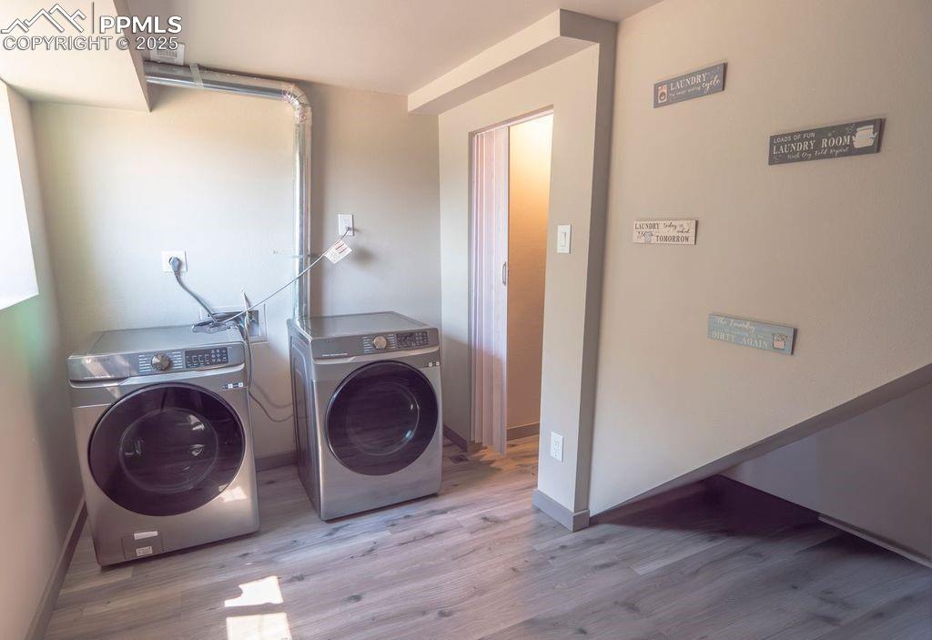 Image 19 of 39: Laundry room featuring washing machine and clothes dryer and wood finished 