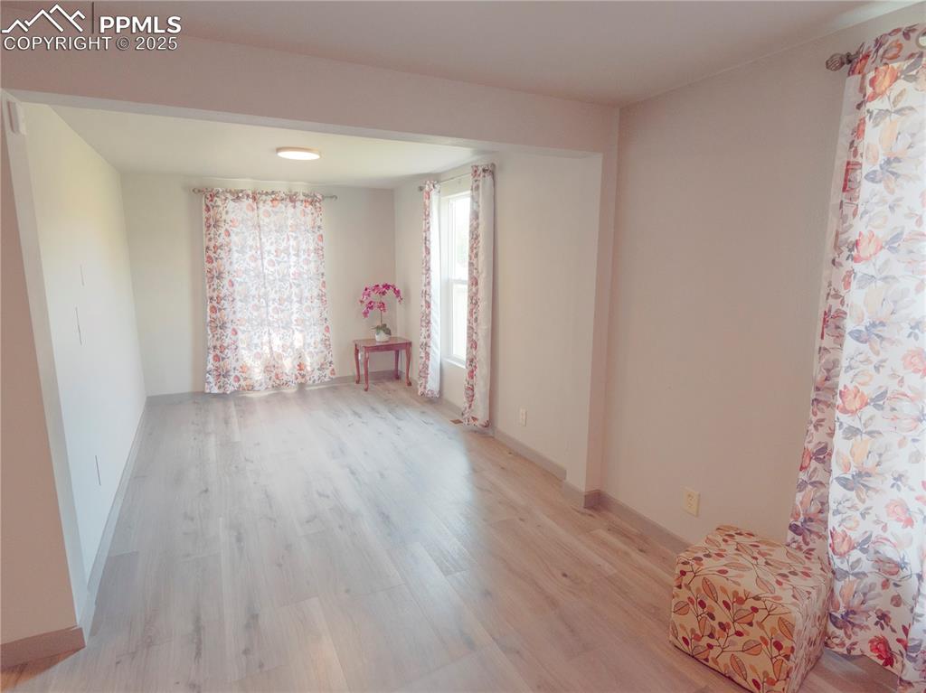 Image 22 of 39: Empty room with light wood-style flooring and baseboards