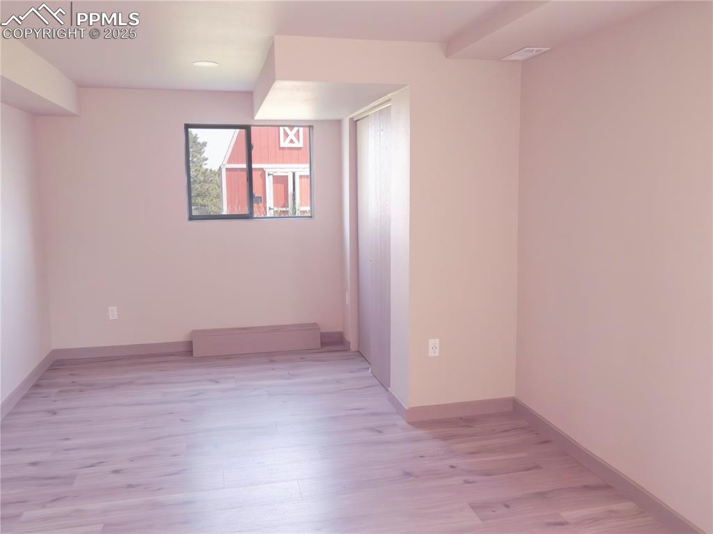 Image 24 of 39: Spare room featuring light wood-type flooring, a baseboard heating unit, an
