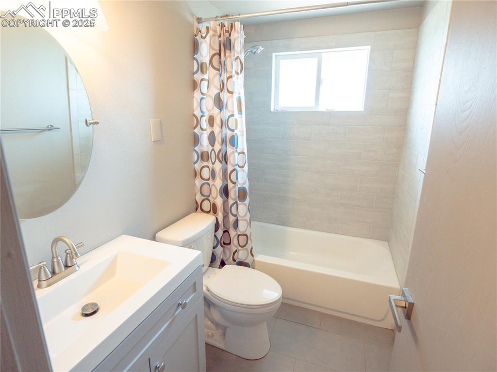 Image 29 of 39: Full bathroom featuring shower / bath combination with curtain, vanity, and