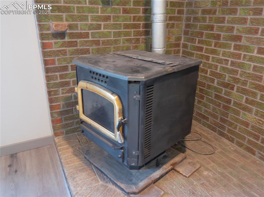 Image 31 of 39: Detailed view of a wood stove and wood finished floors