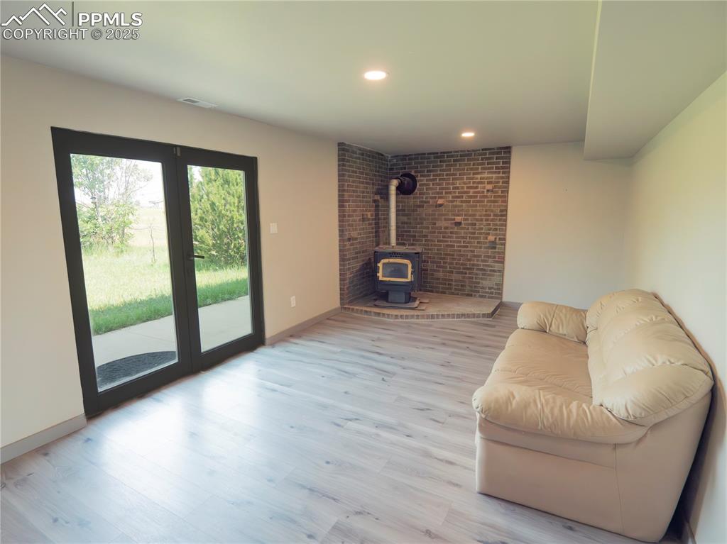 Image 34 of 39: Living area with a wood stove and wood finished floors