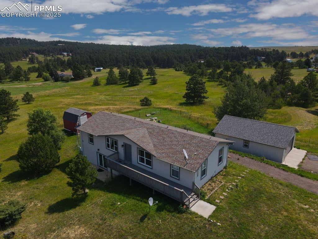 Image 36 of 39: Aerial view of sparsely populated area with a forest