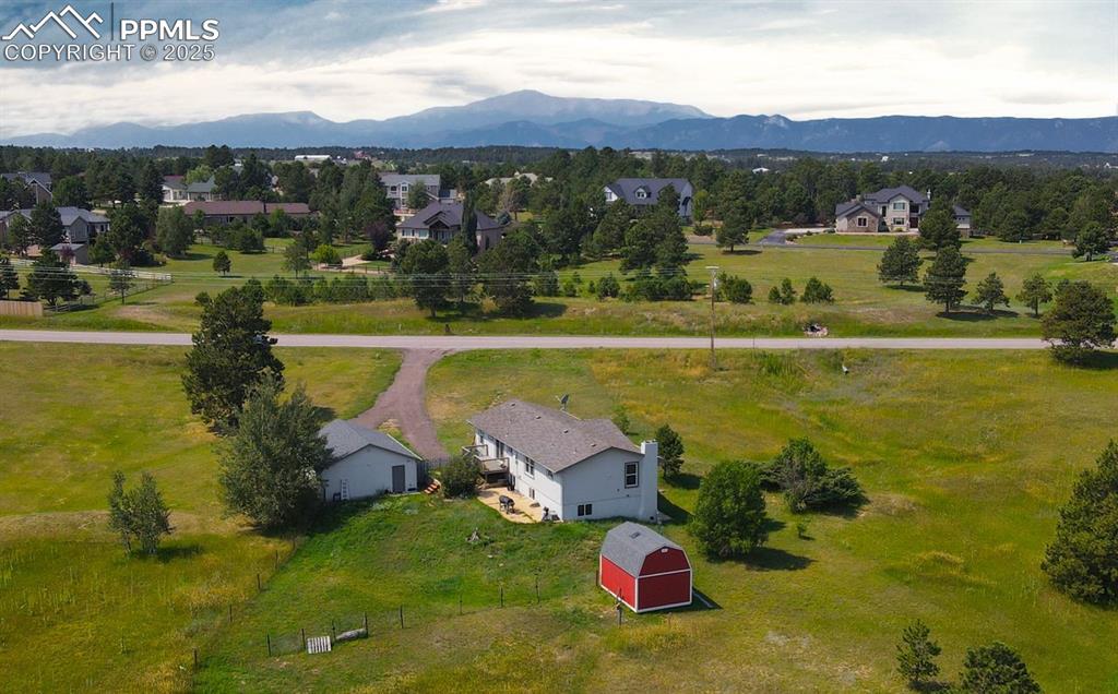 Image 38 of 39: Aerial view of sparsely populated area with a mountain backdrop