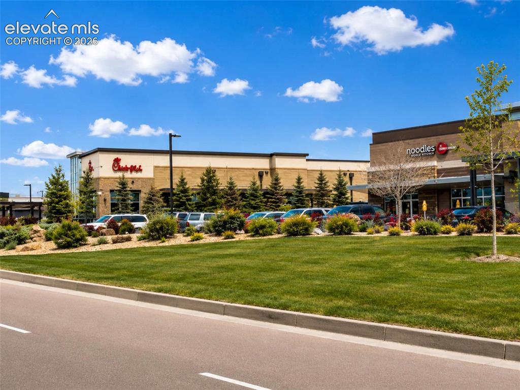 Image 20 of 40: Commercial storefronts featuring a contemporary design with stone and stucc