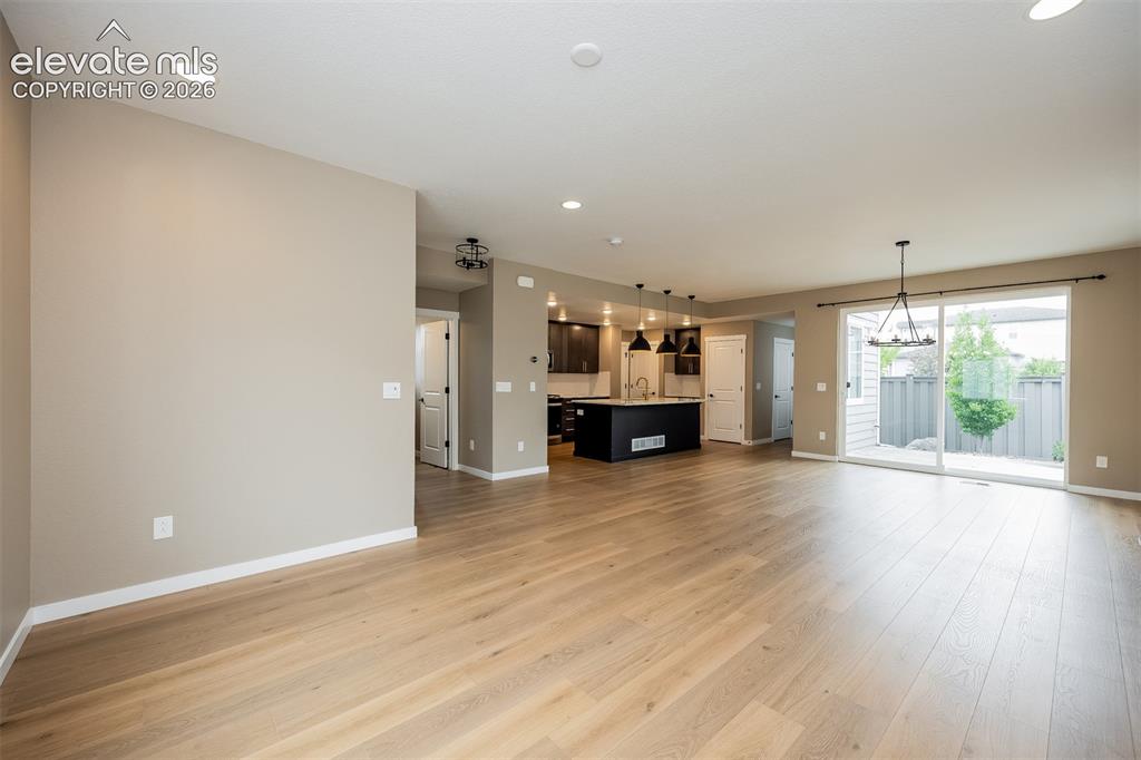 Image 24 of 40: Expansive open-concept living area featuring light wood-finish flooring, re