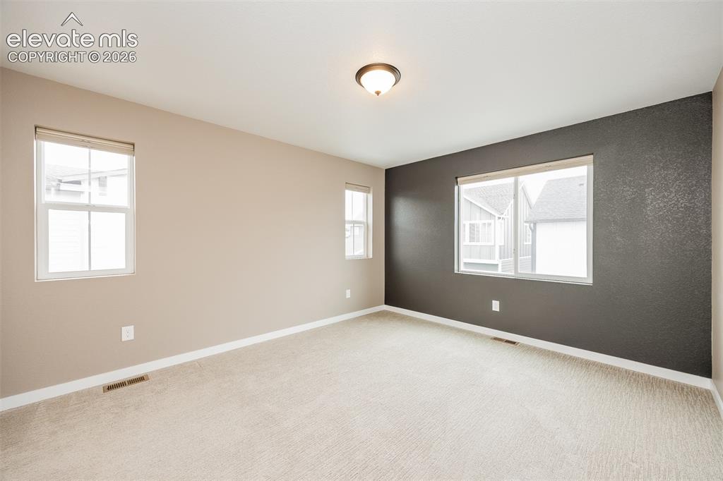 Image 29 of 40: Spacious room featuring neutral carpeting and a two-tone wall treatment wit