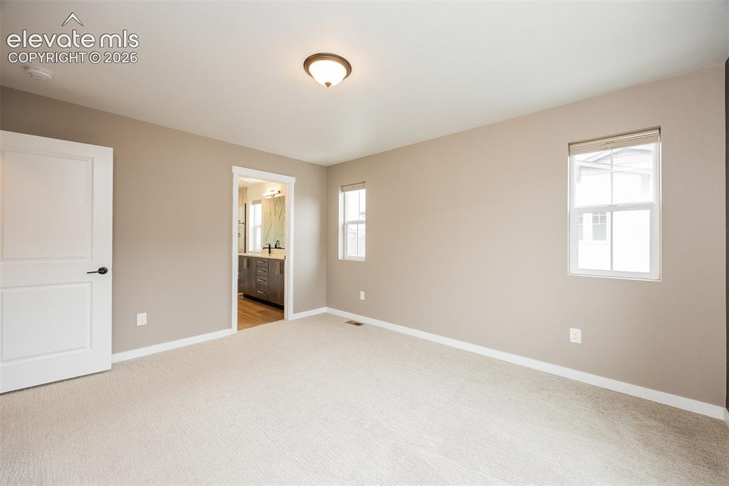 Image 30 of 40: Spacious room with plush carpeting and neutral wall tones