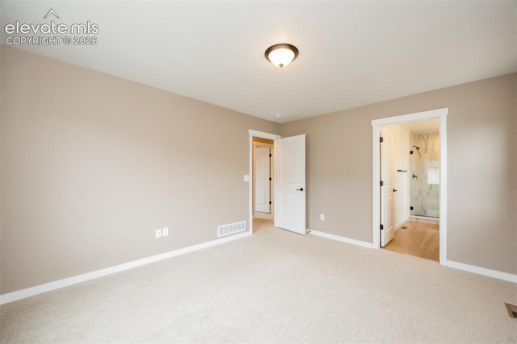 Image 31 of 40: Neutral-toned room with plush carpet flooring
