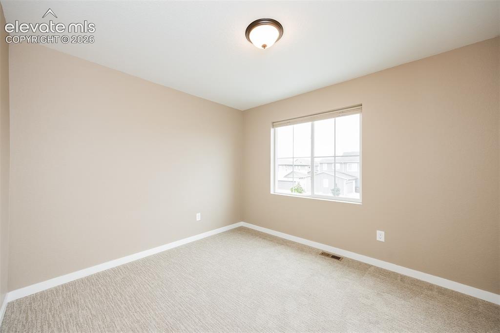 Image 35 of 40: Neutral-toned room featuring a large window, light-colored carpet, white ba