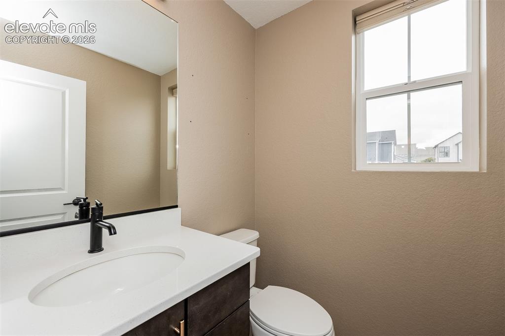 Image 37 of 40: Bathroom featuring a single vanity with dark wood-finish cabinetry, a white