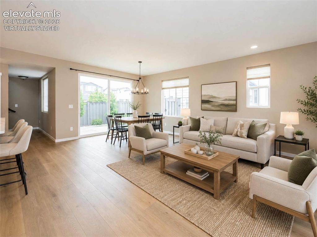 Image 4 of 40: Open-concept living area featuring wood-finish flooring, recessed lighting,