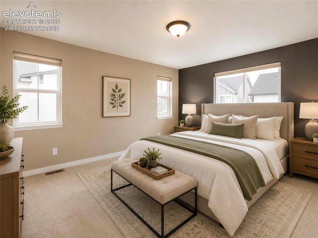 Image 6 of 40: Primary Bedroom featuring neutral carpeting, a dark accent wall, multiple w