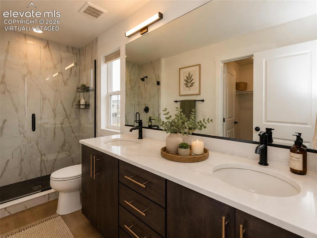 Image 8 of 40: Primary Bathroom featuring a dual-sink vanity with white countertops, dark