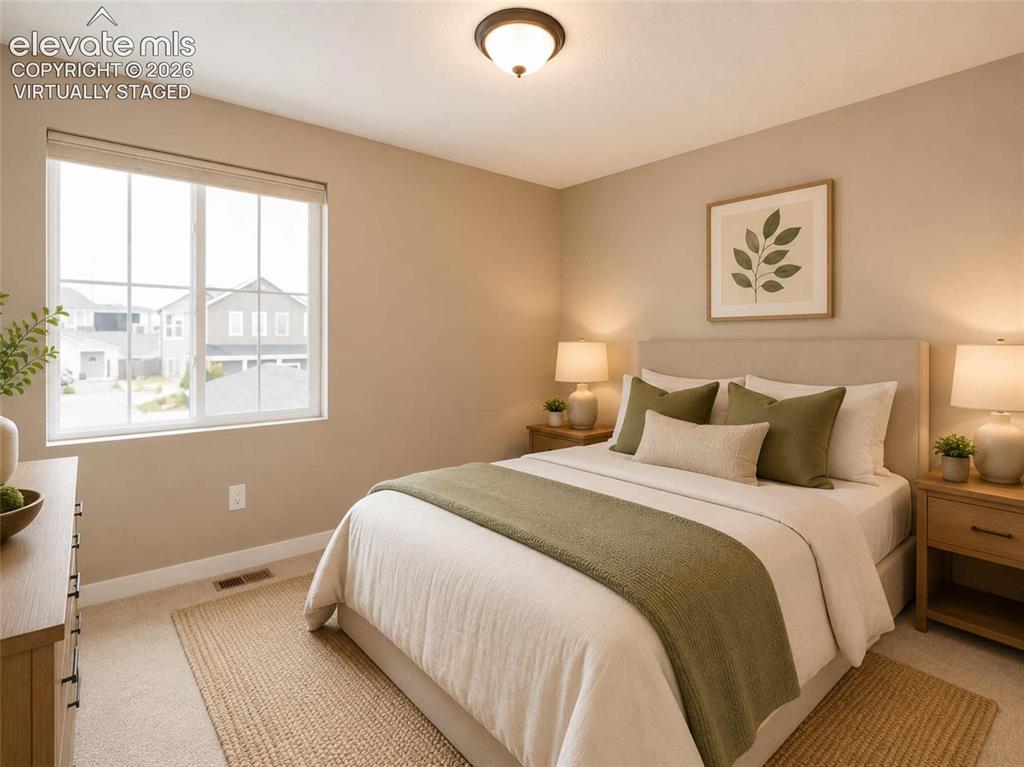 Image 9 of 40: Light-filled bedroom featuring neutral wall tones, carpeted flooring, a win