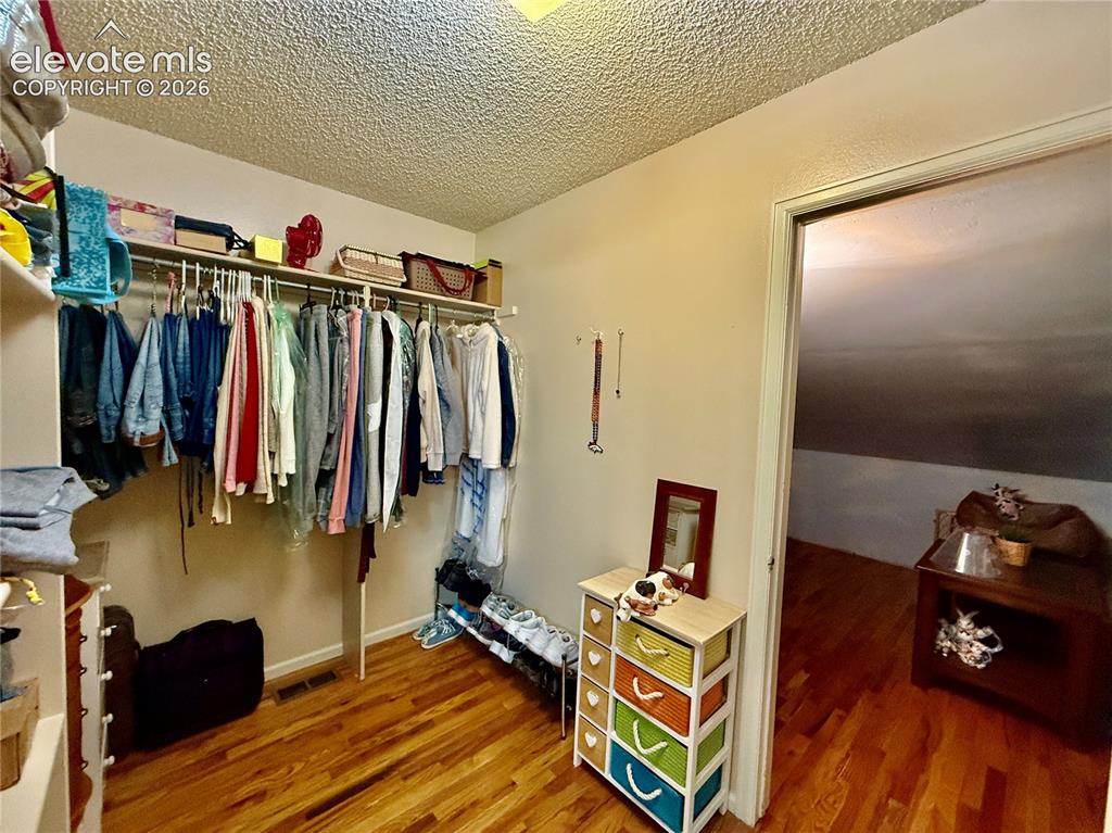 Image 17 of 26: Spacious closet with wood finished floors