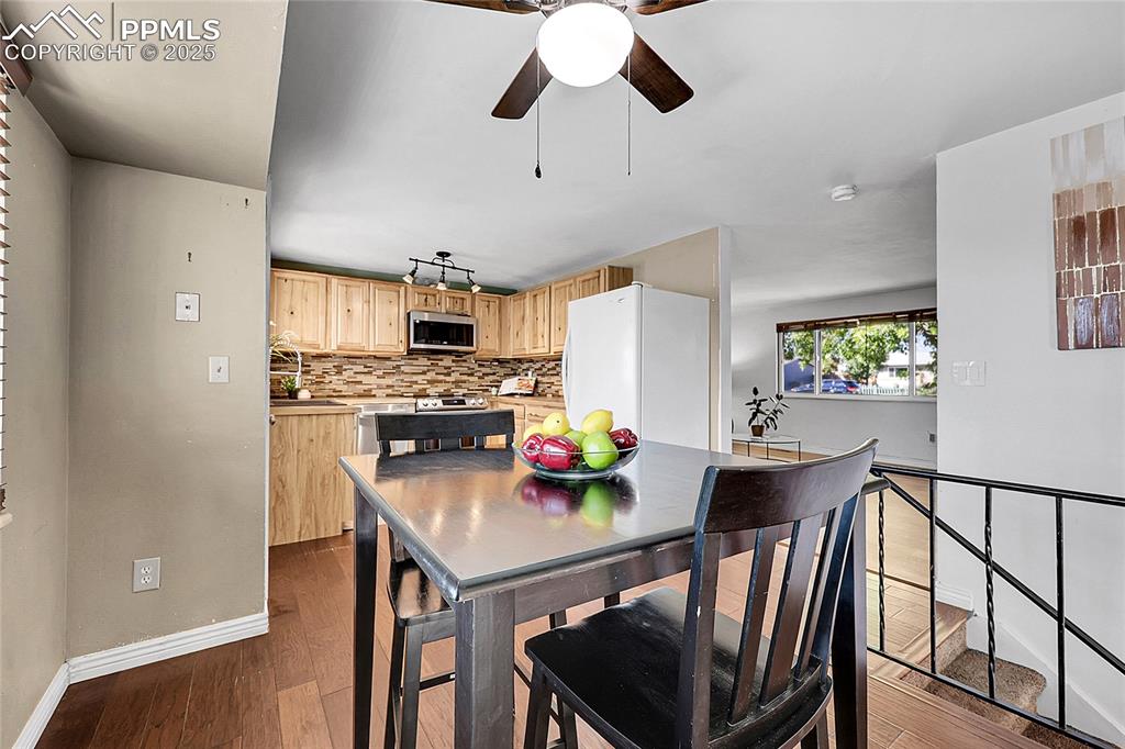 Image 11 of 36: Dining room featuring ceiling fan and dark wood-style flooring
