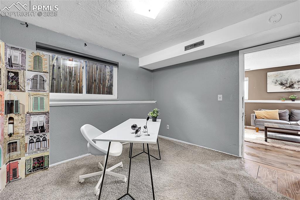 Image 13 of 36: Office area with a textured ceiling, a textured wall, and carpet
