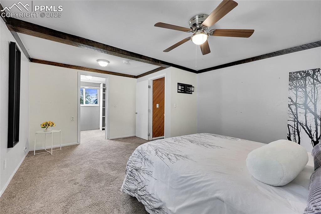 Image 17 of 36: Bedroom featuring carpet floors, a ceiling fan, beamed ceiling, and crown m