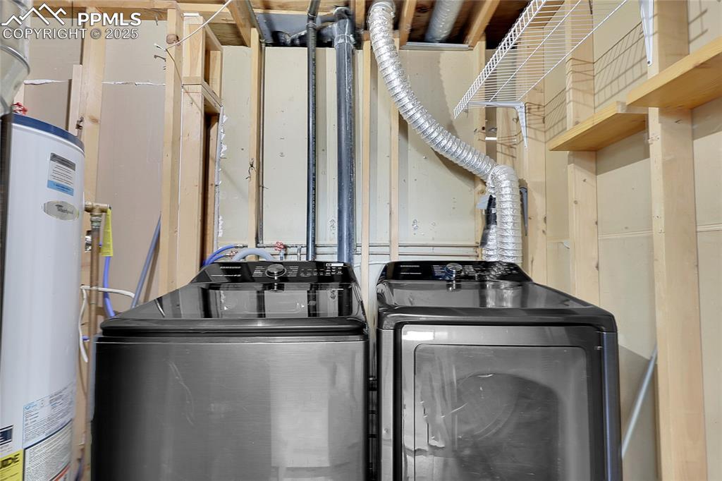 Image 19 of 36: Laundry room with water heater and washer and clothes dryer