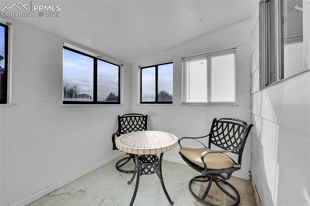 Image 20 of 36: Living area with vaulted ceiling and concrete flooring